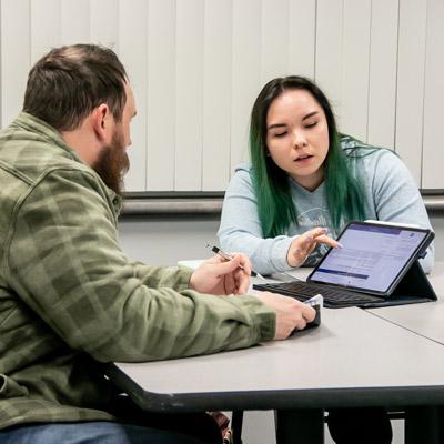 two unk student work at a computer